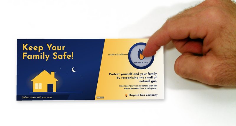 Finger scratching the scratch-and-sniff spot on a sample natural gas safety bill insert